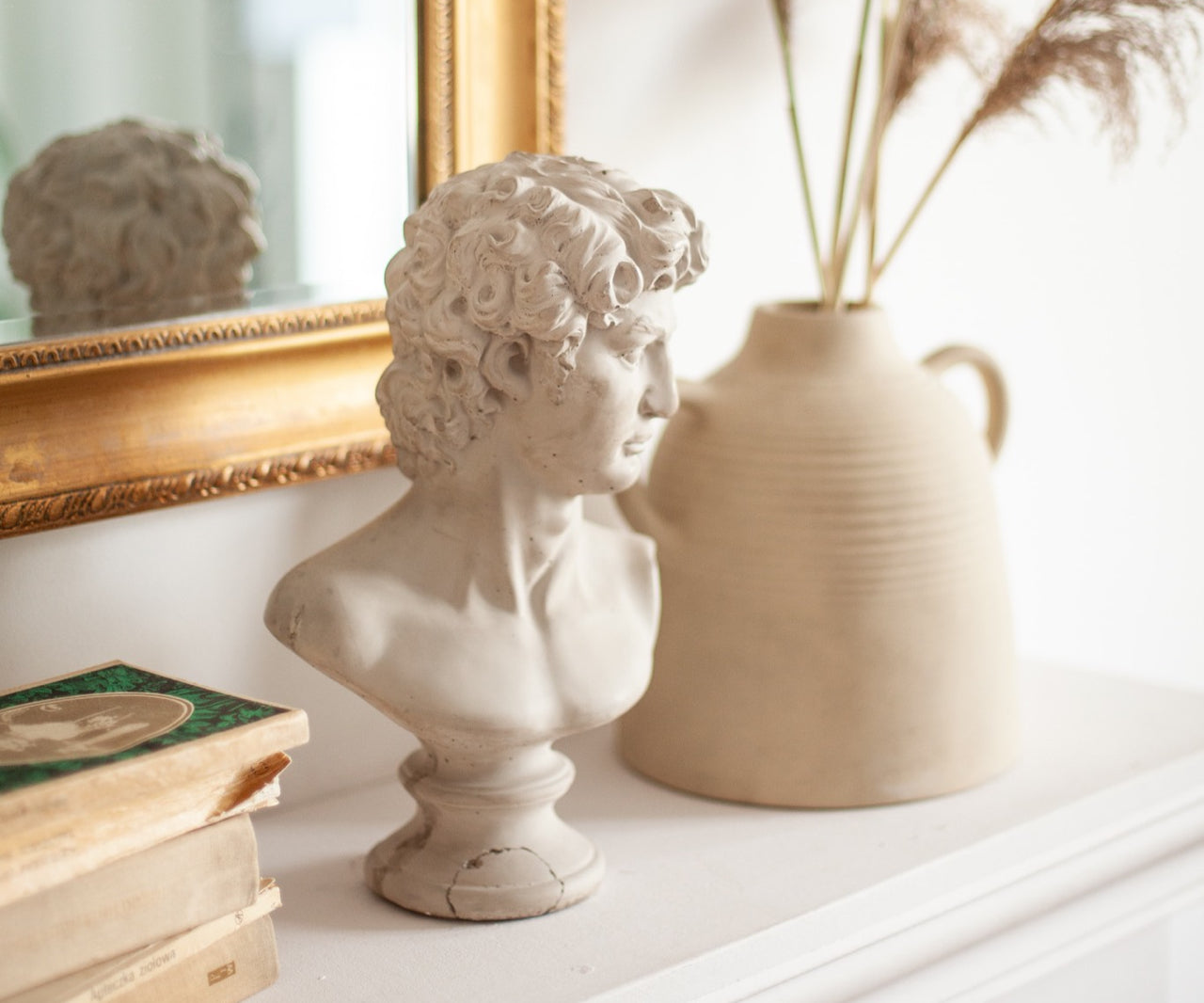 statue and shelf decor on a mantle