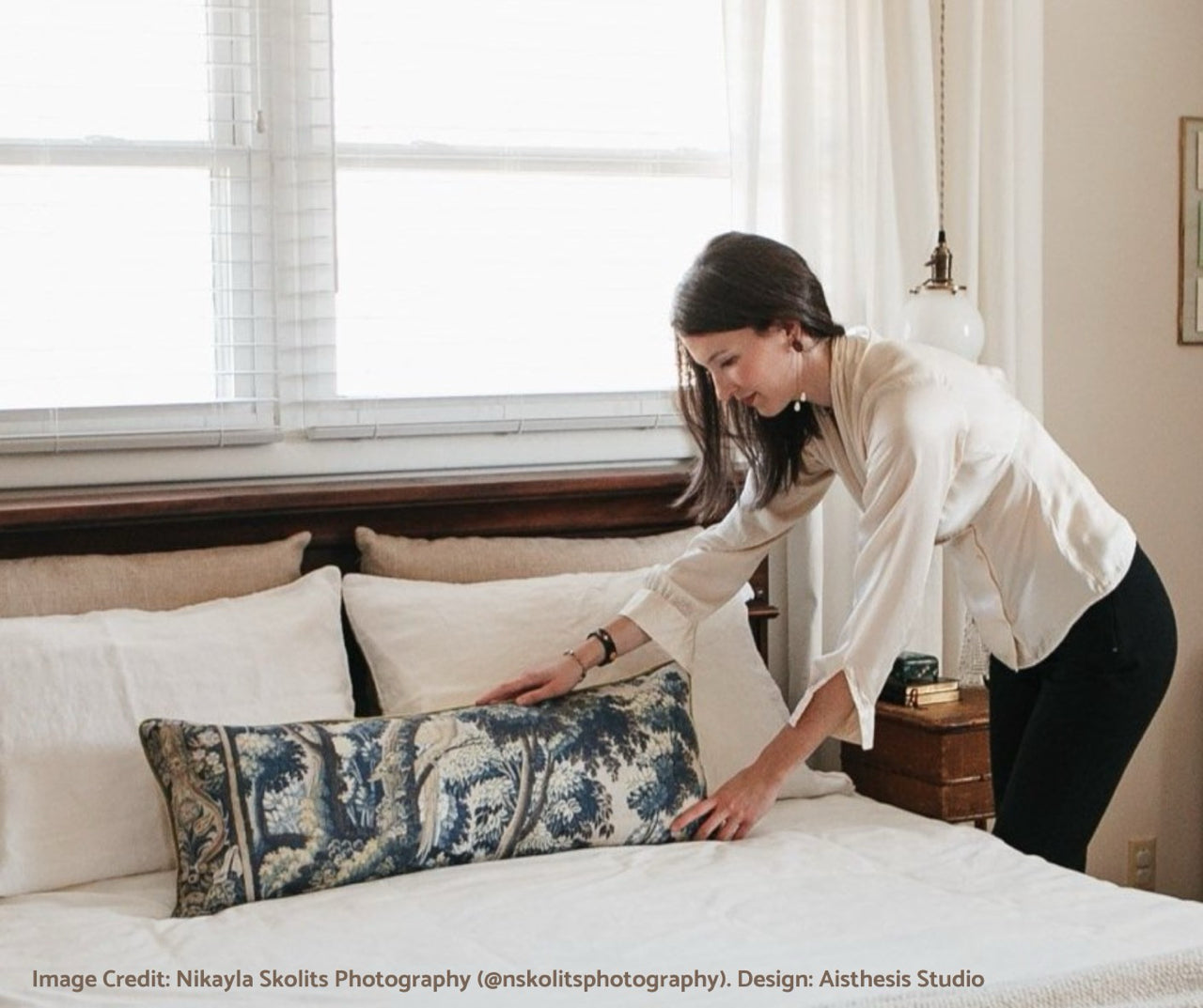 Interior Designer arranging pillow on a bed